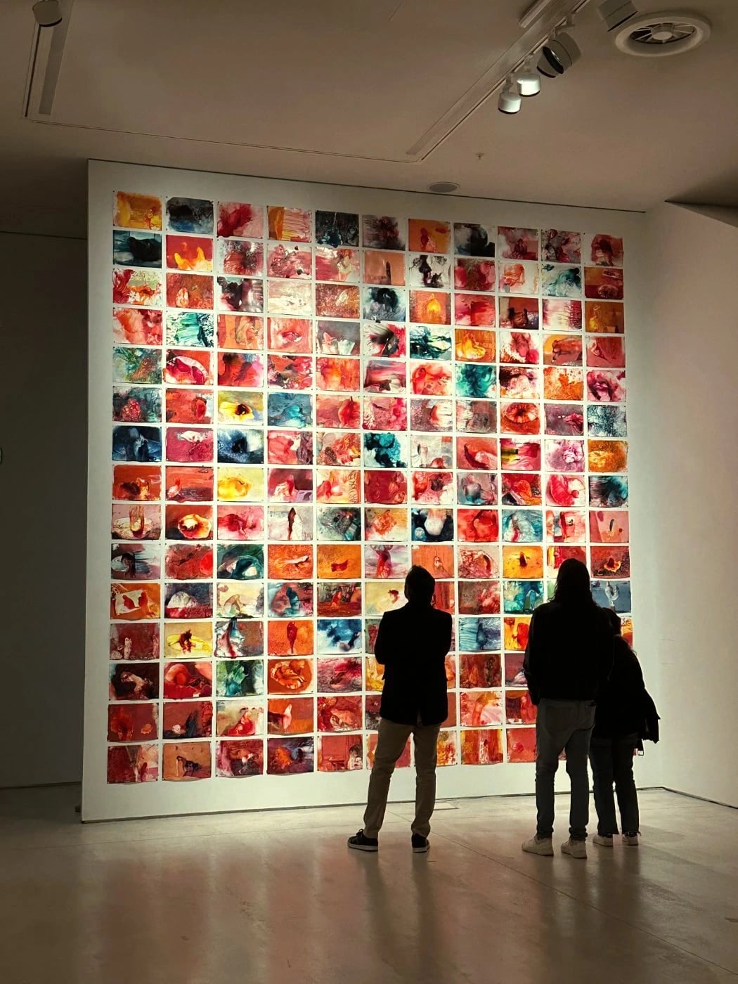 Gallery wall in Athens, visitors from behind